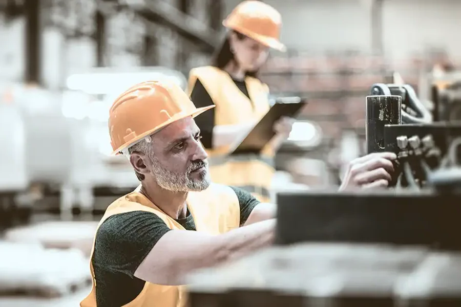 Industrial worker overseeing machinery, symbolizing risk management.