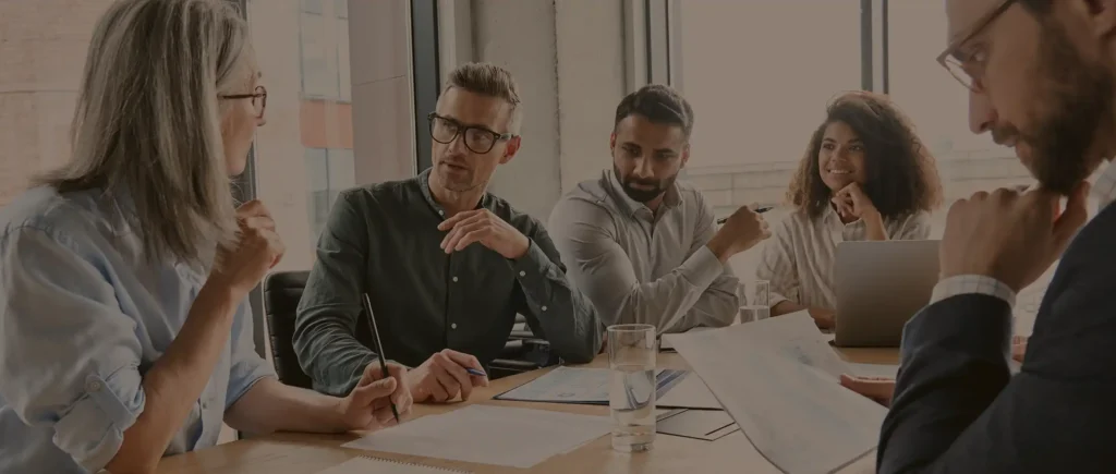 Insurance brokers collaborating with clients at a meeting.