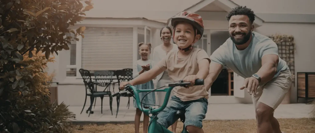 Family moment with father and son on bike, symbolizing personal insurance protection.